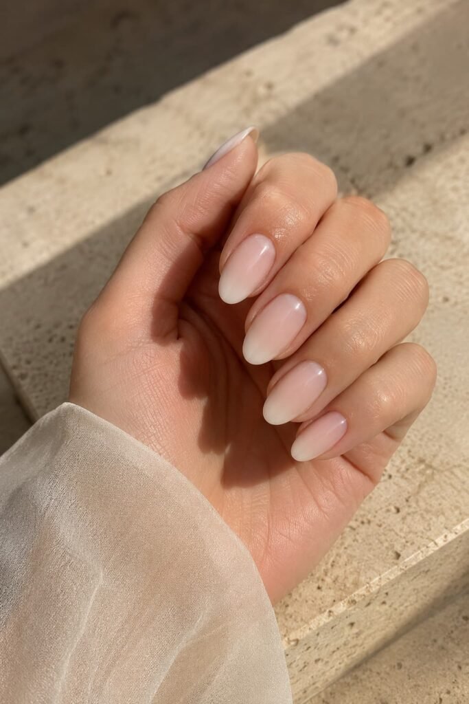 Almond nails with a soft blush-to-milky ivory ombre gradient