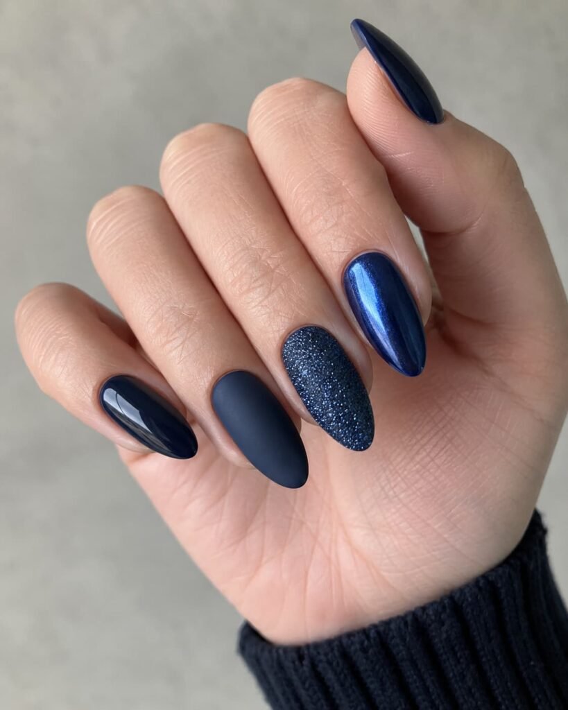 Navy blue almond nails shown with glossy, matte, glitter, and metallic finishes.