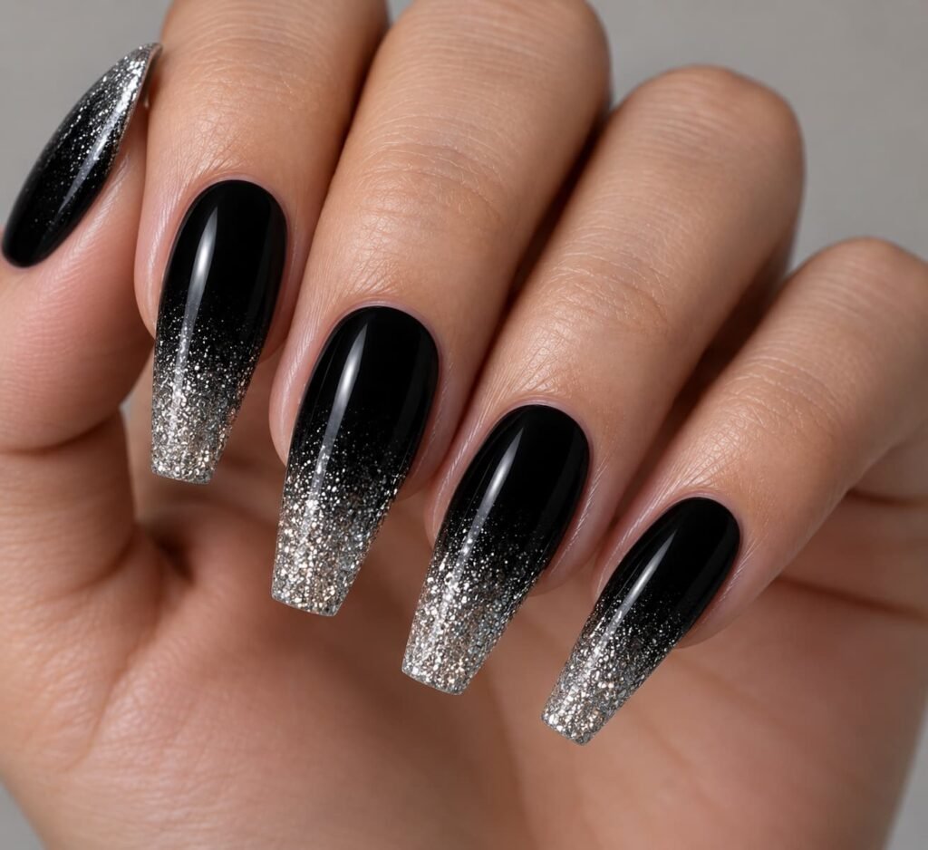 Coffin-shaped nails featuring an ombré gradient from a solid black base to silver glitter tips.