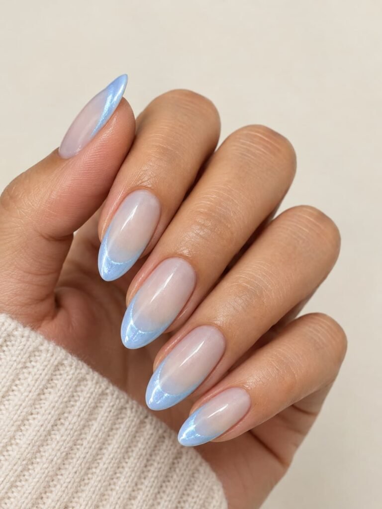 Light blue cat eye French tip manicure with curved icy-blue tips and subtle magnetic shimmer.