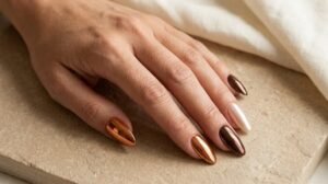 Almond nails with copper, chocolate brown, and champagne chrome finishes.