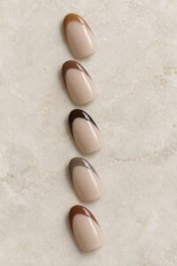 Five oval nail samples with caramel, chocolate, espresso, taupe, and reddish-brown French tips.