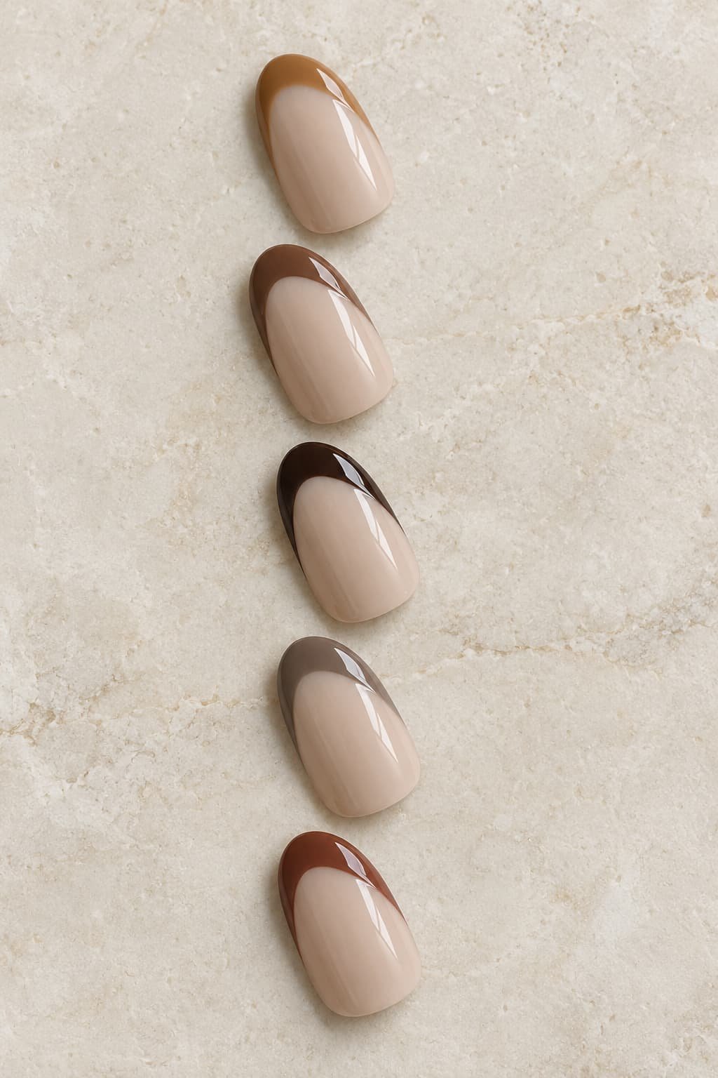 Five oval nail samples with caramel, chocolate, espresso, taupe, and reddish-brown French tips.